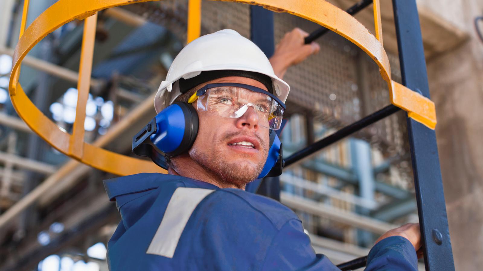 Man in safety gear climbing ladder