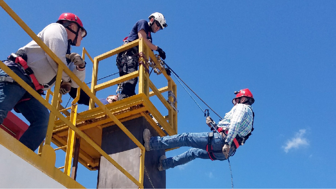 3 men work high up using harnesses